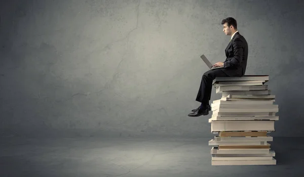 Étudiant assis sur une pile de livres — Photo