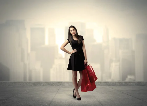 优雅的城市女孩，戴着红色购物袋 图库图片