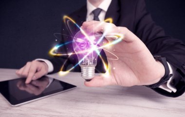 renkli bir ampul tutan işadamı