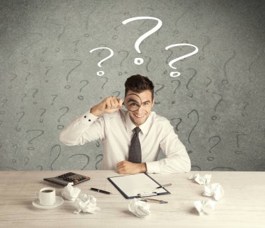 İş adamı soru işaretiyle masada.