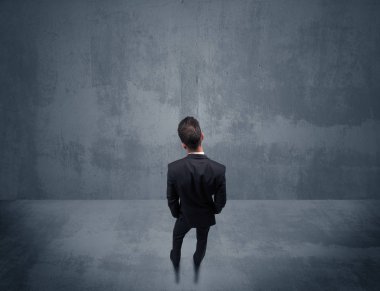 Şehir duvarının önünde duran iş adamı