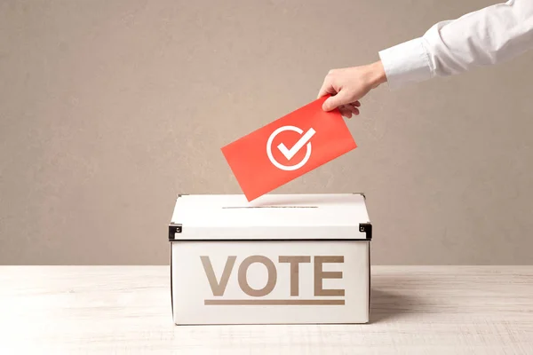 Fechar a mão masculina colocando voto em uma urna — Fotografia de Stock