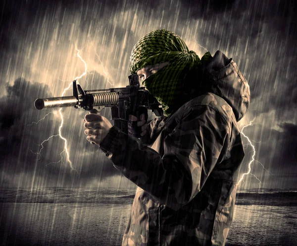 Gefährlicher bewaffneter Terrorist mit Maske und Waffe im Gewitter — Stockfoto