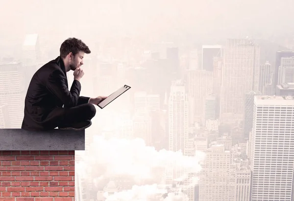 Trabalhador de escritório sentado no telhado na cidade — Fotografia de Stock