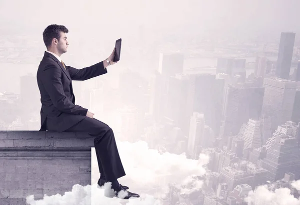 Sales person sitting on building edge in city — Stock Photo, Image