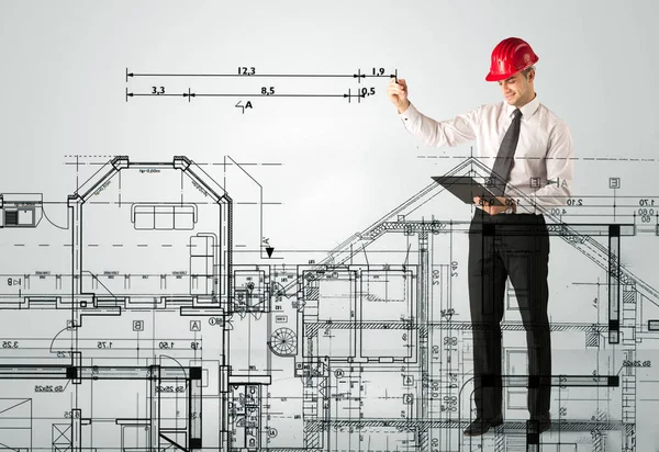 Genç bir mimar ev planı çiziyor.