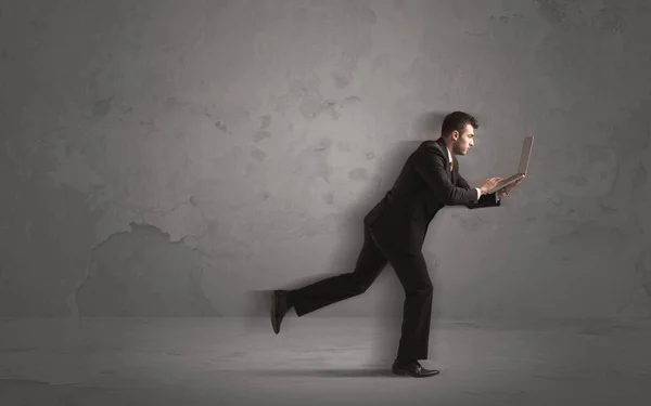 Running businessman with device in hand