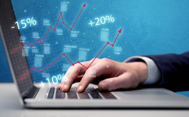 Satıcı dizüstü bilgisayarla grafikle çalışıyor.