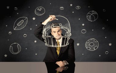 İş adamı miğfer ve spor topu çiziyor.