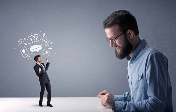 Young businessman fighting with miniature businessman — Stock Photo, Image