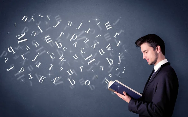 Jovem segurando livro com letras — Fotografia de Stock