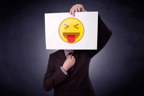 Empresario sosteniendo papel con emoticono —  Fotos de Stock