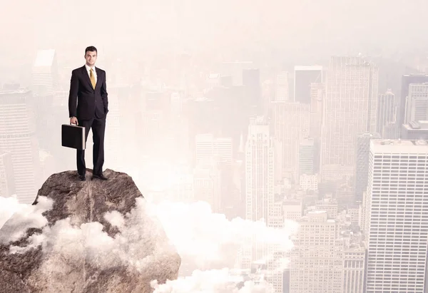 Happy businessman standing on stone top — Stock Photo, Image