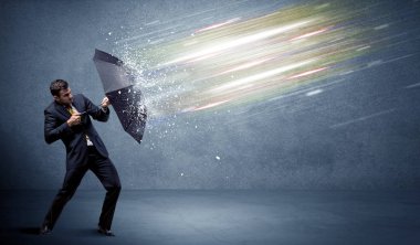 Şemsiye konseptiyle ışık demetlerini savunan iş adamı