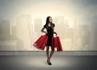 Alışveriş torbalarıyla duran şehir kadını.