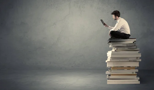 Étudiant assis sur une pile de livres — Photo