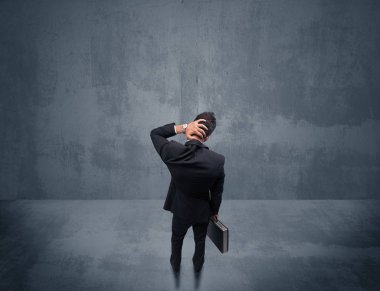 Şehir duvarının önünde duran iş adamı