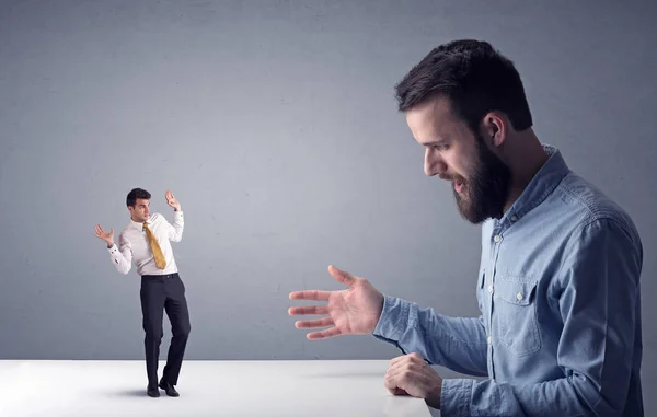 Joven hombre de negocios luchando con empresario en miniatura — Foto de Stock