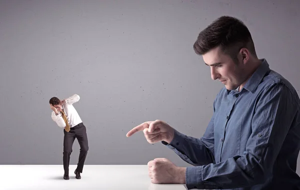 Joven hombre de negocios luchando con empresario en miniatura —  Fotos de Stock