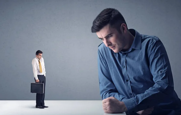 Young businessman fighting with miniature businessman — Stock Photo, Image