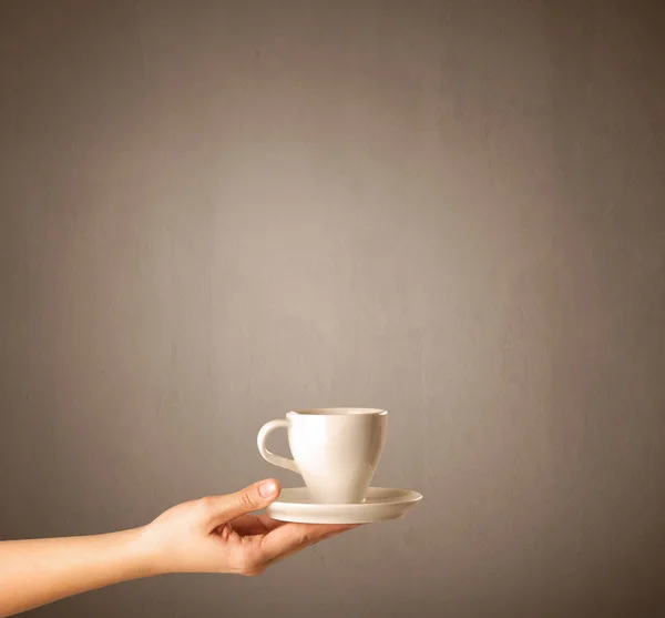 Vrouwelijke hand bedrijf koffie beker — Stockfoto