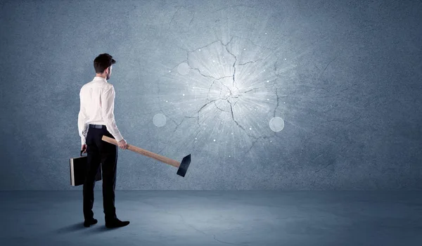 Hombre de negocios golpeando la pared con un martillo —  Fotos de Stock