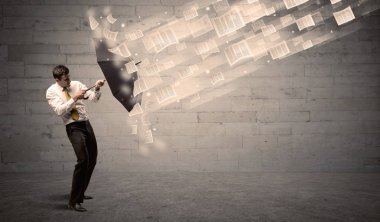 İş adamı ile şemsiye kağıtları rüzgara karşı koruma