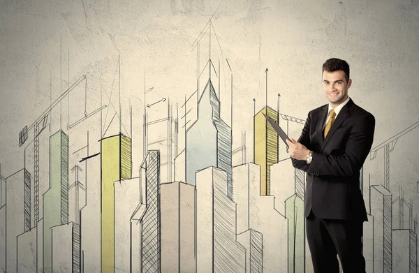 Businessman standing with drawn cityscape — Stock Photo, Image