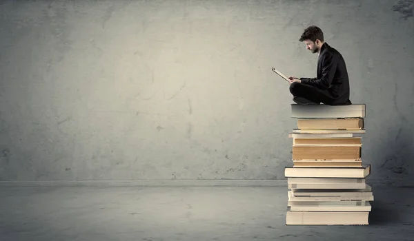 Man met laptop zitting op boeken — Stockfoto