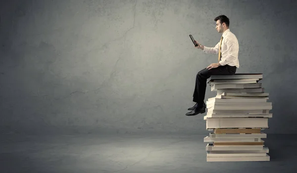 Étudiant assis sur une pile de livres — Photo