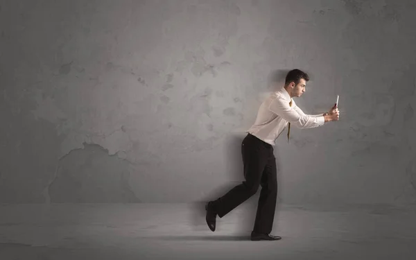 Running businessman with device in hand