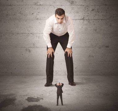 Büyük bir iş adamı küçük bir iş arkadaşına bakıyor.