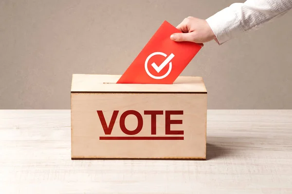 Close up of male hand putting vote into a ballot box — Stock Photo, Image