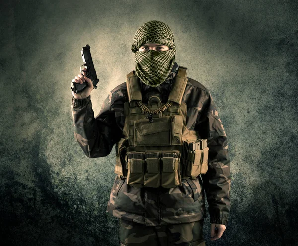 Portrait of a heavily armed masked soldier with grungy backgroun — Stock Photo, Image