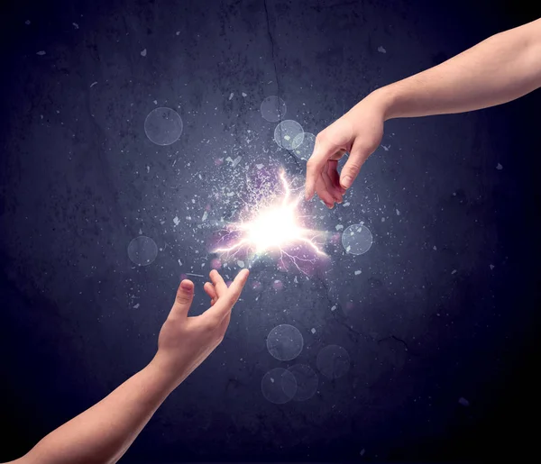 Hands reaching to light a spark — Stock Photo, Image