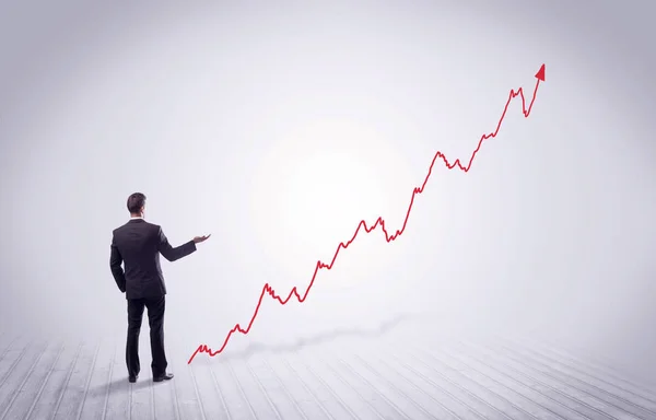 赤いグラフの矢印で立っているビジネスマン — ストック写真