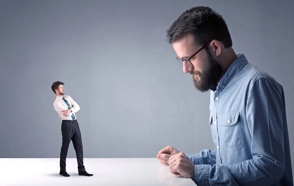 Giovane uomo d'affari che lotta con uomo d'affari in miniatura — Foto Stock