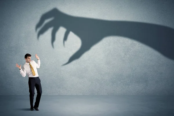 Pessoa de negócios com medo de um grande conceito de sombra de garra monstro — Fotografia de Stock