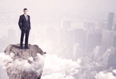 Kayanın üzerinde duran kazanan iş kişi