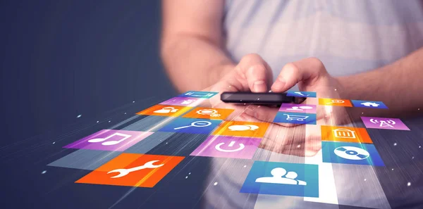 Homem segurando telefone inteligente com ícones de aplicação coloridos — Fotografia de Stock