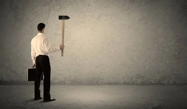 Homme d'affaires debout devant un mur grincheux avec un marteau — Photo