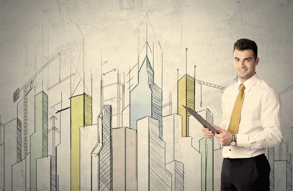 Businessman standing with drawn cityscape — Stock Photo, Image