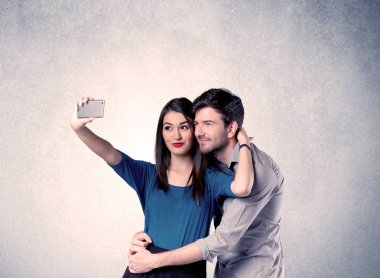 Mutlu çift temiz duvarlı selfie çekiyor.