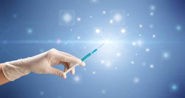 Kadın doktor elinde şırınga tutuyor.