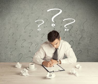 İş adamı soru işaretiyle masada.