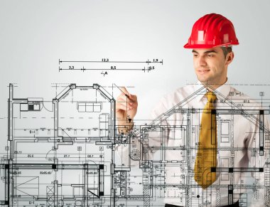 Genç bir mimar ev planı çiziyor.