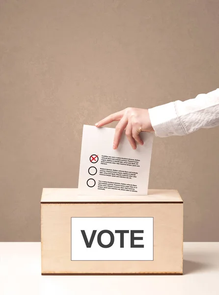 Close up of male hand putting vote into a ballot box — Stock Photo, Image