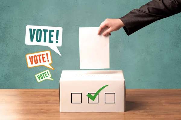 Placing a voting slip into a ballot box — Stock Photo, Image