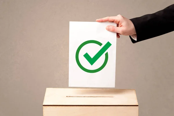 Primer plano de la mano masculina poniendo el voto en una urna — Foto de Stock