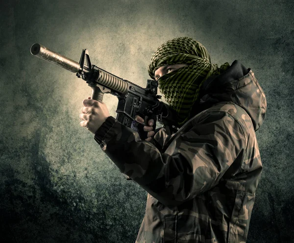 Porträtt av en tungt beväpnade maskerade soldat med grungy bak — Stockfoto
